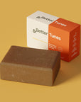 &Better Tunes Exfoliating + Moisturizing Body Bar. Our natural body bar is made with high-quality ingredients, premium essential oils, and powered with kelp powder and pumice. Natural formula cleans and hydrates your skin and offers a spa-grade sensorial experience. The cold processed body bar preserves the benefits of hand-harvested, organic, and sustainably grown shea butter and other natural oils. Plastic-Free. Organic Shea Butter