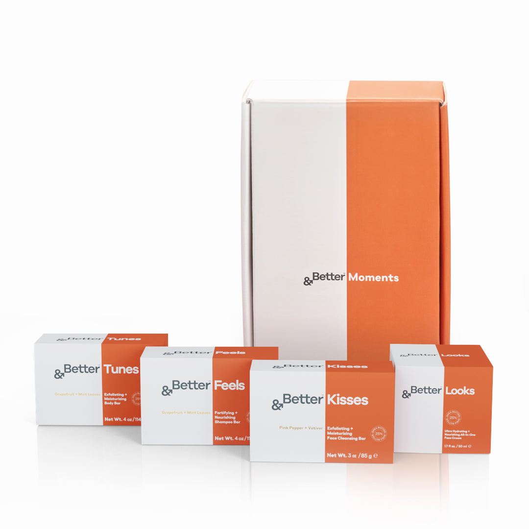 &Better Moments Gift Set displayed, featuring all-natural, plastic-free products including the &Better Feels Shampoo Bar, &Better Tunes Body Scrub Bar, &Better Kisses Face Cleansing Bar, and &Better Looks Face Cream, showcasing the brand's commitment to sustainability and high-quality personal care