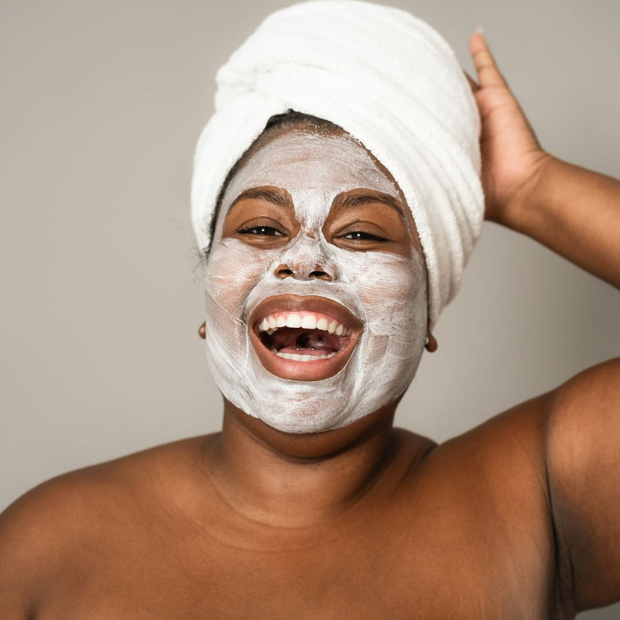 A happy, curvy African woman enjoying a skincare spa day, embodying the concept of self-care and personal wellness