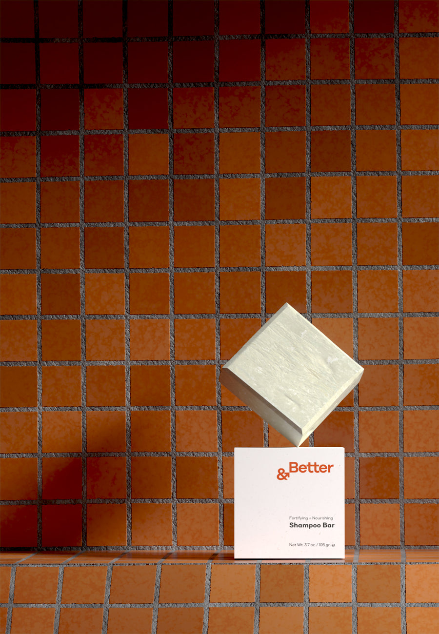 &Better's all-natural, eco-friendly shampoo bar displayed on brick tiles in a minimalist, modern bathroom setting